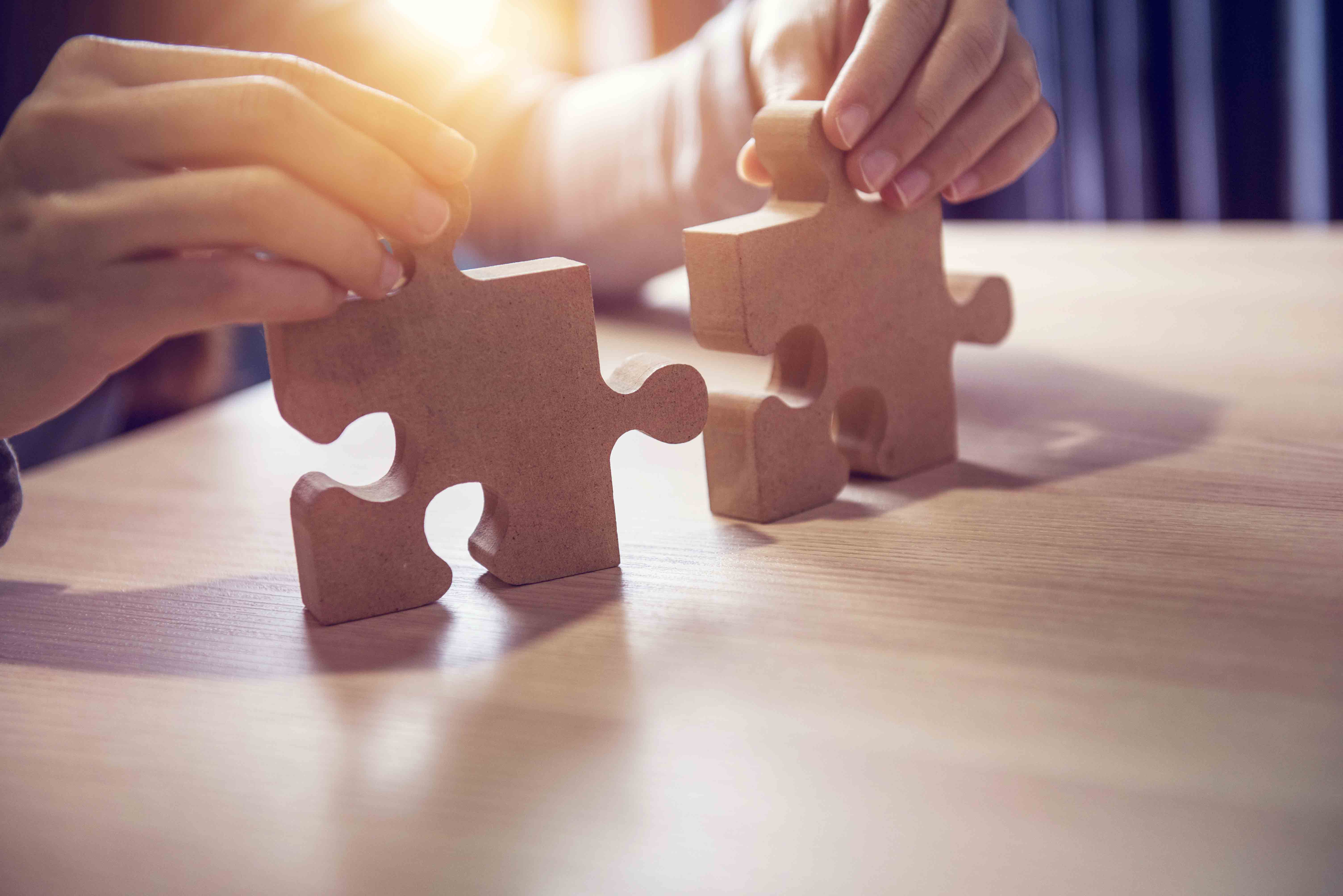 Businesswoman hand connecting jigsaw puzzle on desk, Business so